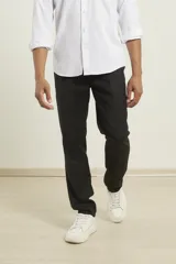 Pantalón de vestir azul marino, de corte recto, con bolsillos laterales y traseros. Se ajusta a la cintura con cinturón de cuero negro.