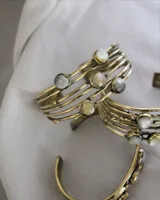 Pulsera rígida de bronce con apliques de nácar. Se ajusta a presión.