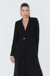 Blazer negro de viscosa con corte entallado, cuello sastre, manga larga con hombreras, bolsillos delanteros con solapa, forro y cierre frontal con botón.