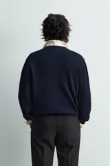 Jersey de punto de algodón, color azul marino, con cuello en V y manga larga.