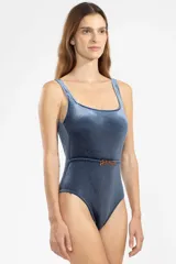 Malla entera azul de terciopelo con textura acanalada, escote cuadrado, breteles anchos y cinturón con hebilla dorada en forma de tigre.