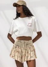 Minifalda con estampado floral, diseño de tiro alto con detalle de cordones frontales tipo corset y falda con volados.