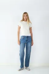Jeans tiro alto de corte recto, diseño clásico de cinco bolsillos, presillas para cinturón y cierre frontal con cremallera y botón metálico.