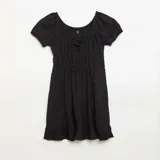 Vestido corto de manga corta color negro con escote cuadrado, detalle de lazo en el pecho y diseño fruncido con volado en el ruedo.