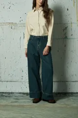 Jean de corte wide leg en color azul oscuro, con tiro medio y ruedo ancho con costura reforzada.