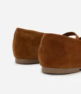 Zapatilla chatita femenina en gamuza color marrón, con punta redonda y tira con hebilla lateral.