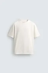 Camiseta de corte relajado confeccionada en algodón, con cuello redondo acabado en rib y manga corta.