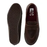 Championes tipo mocasín Vans, confeccionados en cuero marrón con diseño inspirado en el skate. Presentan una construcción vulcanizada con suela waffle, detalles de tachuelas en la lengüeta y adornos metálicos removibles.
