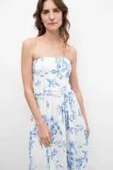 Vestido midi strapless con estampa floral azul sobre fondo blanco, con cinturón.