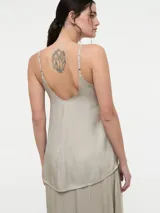 Top de tirantes finos con escote en V, confeccionado en tela satinada con caída fluida.