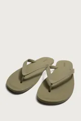 Sandalia plana de goma, color verde oscuro con tiras cruzadas en el empeine en tono beige.