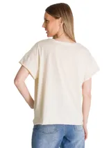 Remera de corte relajado color beige, con cuello redondo y mangas cortas. Presenta un estampado gráfico frontal con motivos botánicos y tipografía retro en tonos verde y rosado.