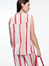 Chaleco sin mangas con cuello en V, con cierre frontal abotonado y bolsillos de parche. Diseño a rayas verticales en tonos beige, azul y marrón.