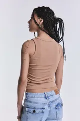 Musculosa camel de tejido rib, al cuerpo, con detalles de tachas metálicas aplicadas en el cuello y las sisas.