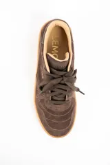 Zapatilla urbana de gamuza color marrón, con cordones al tono, suela de goma color caramelo y logo de la marca grabado en el lateral.