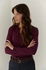 Remera manga larga color borgoña con cuello en V y costuras decorativas verticales.