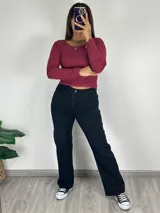 Pantalón de jean negro de corte wide leg, tiro alto y bolsillos delanteros y traseros.