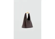 Bolso de mano tipo hobo, confeccionado en poliuretano color marrón oscuro con acabado liso. Presenta un diseño minimalista con una estructura rígida y un asa superior metálica en tono dorado.