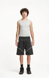 Bermuda negra de textil liviano con calce oversize, elástico y cordón de ajuste en la cintura. Presenta recortes con ribetes reflectantes grises en los bolsillos delanteros y ribetes blancos en el ruedo. Posee bolsillos traseros.