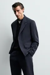Blazer de corte regular confeccionado en lana de origen italiano. Presenta cuello con solapas de muesca, cierre frontal de un botón, bolsillos laterales con solapa y bolsillo de vivo en el pecho. Incluye abertura central en la espalda y forro interior.