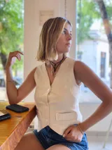 Gargantilla con cordón negro y dije metálico plateado en forma de estribo.