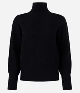 Suéter de manga larga confeccionado en tricot, con cuello alto y diseño de bordado de rombos en relieve. Presenta puños y ruedo acanalados.