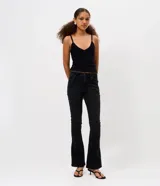 Pantalón de jean negro modelo bootcut y tiro bajo, de calce ajustado en la cadera con apertura sutil en la botamanga. Presenta bolsillos funcionales y cierre tradicional con botón y cremallera.
