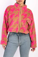 Campera corta de polar color beige con estampado de estrellas negras, cuello alto y cierre frontal.