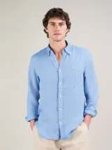 Camisa lisa de hombre color celeste, confeccionada en 100% lino. Presenta un corte regular fit, cuello italiano, cierre con botones, manga larga terminada en puño simple y logo de El Ganso bordado en el pecho.