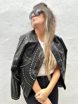 Chaqueta negra de cuero sintético con tachas plateadas, lentejuelas y strass.