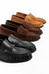 Mocasines de cuero de estilo clásico inspirados en el mocasín náutico, con puntera redondeada con costuras y fruncidos, y tira decorativa en la capellada.