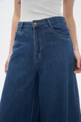 Pantalon de jean azul de corte ancho y tiro alto, con ruedo deshilachado.
