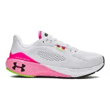 Championes de running Under Armour modelo HOVR Machina 3 para mujer. Diseño en color blanco con detalles en fucsia neón y verde lima. Presenta tecnología de amortiguación reactiva UA HOVR, refuerzo externo de TPU en el talón y suela de goma con canales de flexión para mayor durabilidad y retorno de energía.