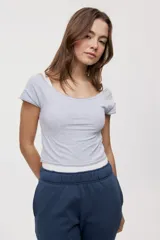 Remera blanca de corte ajustado y largo cropped, con escote redondo amplio y mangas cortas.