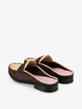 Mule tejido con silueta clásica y punta definida, color beige y negro.