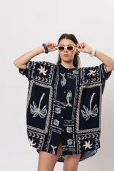 Camisa oversize azul marino con estampado de motivos marinos, palmeras y elementos geométricos en tonos claros. Presenta cuello mao y cierre frontal de botones.