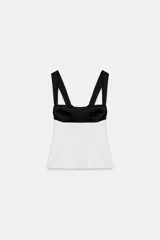 Top de escote cuadrado y tirantes anchos, con diseño bicolor en negro en la parte superior y blanco en el cuerpo, corte ligeramente acampanado y espalda descubierta con lazada.
