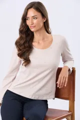 Remera de algodón color beige con sutil estampado floral en tonos pastel, escote redondo y manga larga.