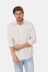 Camisa celeste con rayas verticales blancas, de lino y corte slim fit, con cuello clásico y cierre frontal con botones.