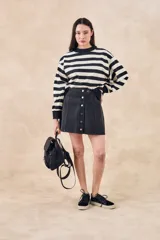 Minifalda gris de jean con botones plateados al frente.