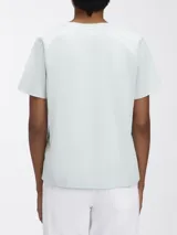 Remera de algodón orgánico de manga corta y cuello redondo, color celeste pálido. Presenta un pequeño logo tonal de Calvin Klein en la parte superior central del pecho.