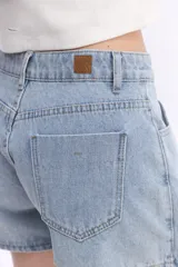 Short pollera de jean negro, con diseño cruzado asimétrico en el frente, bolsillos y tiro alto.
