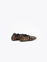 Mary Jane Iris Wild de pelo sintético con estampado animal print de leopardo y detalles en cuero vacuno negro. Cuenta con tiras cruzadas con hebillas metálicas y una base plana de 1 cm.