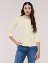 Cardigan de punto fino color amarillo con escote a la base, mangas tres cuartos y abotonadura frontal con botones metálicos decorativos.