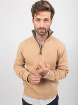 Sweater de punto color tostado con cuello alto y cierre frontal parcial. Presenta puños y ruedo acanalados, con un diseño clásico y versátil.