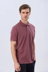 Remera polo de piqué de algodón color azul, de manga corta, con cuello camisero, cierre frontal de dos botones y pequeño logo bordado en el pecho.