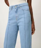 Pantalón recto de jean color azul oscuro, tiro alto, con costuras aparentes en contraste, trabillas en la cintura, cierre tradicional y bolsillos.