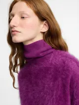 Sweater negro de tejido fino con textura peluche y cuello alto estilo tortuga. Modelo de corte holgado.