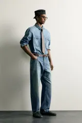 Camisa relaxed fit confeccionada en denim ligero de algodón, con cuello solapa, manga larga con puño abotonado, dos bolsillos de parche en el pecho con solapa y cierre frontal de botones. Presenta un efecto de lavado desgastado.