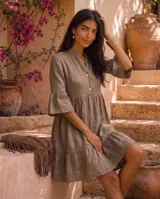 Vestido corto verde militar de lino, con cuello mao, escote en V con botones, mangas tres cuartos acampanadas con volados y falda con volado en el ruedo.